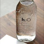Close-up of a sparkling water bottle on a wooden table, refreshing and hydrating.